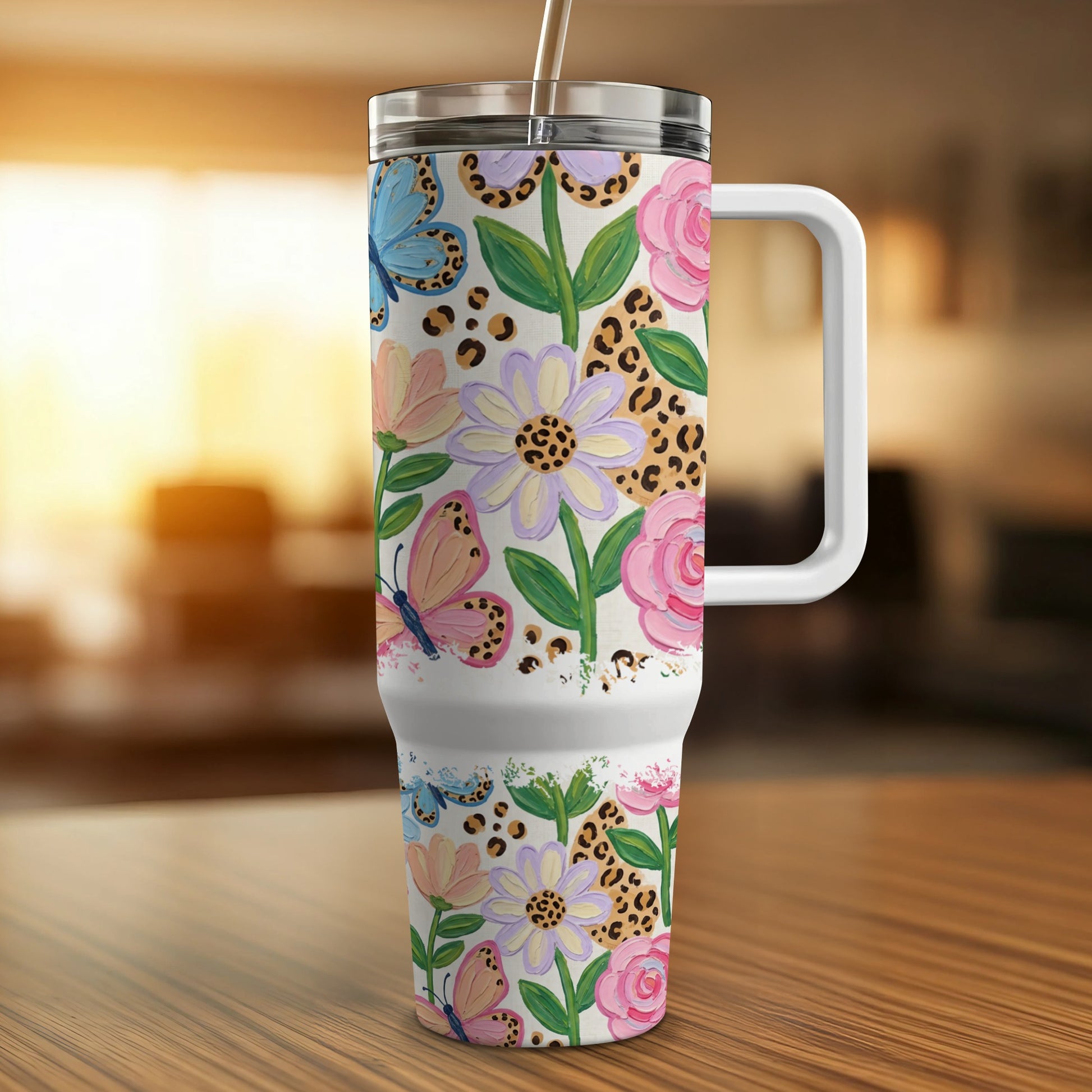Butterfly and floral pattern tumbler with a handle on a wooden surface.