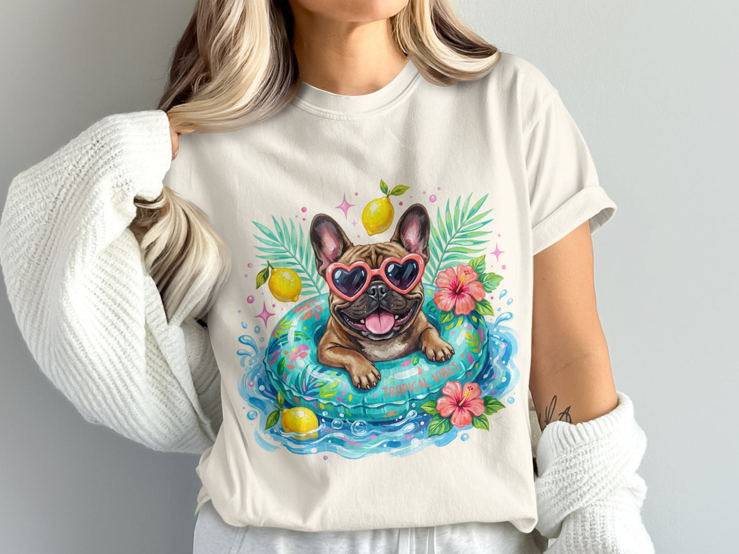 French bulldog in sunglasses floats in inner tube with lemons and flowers.