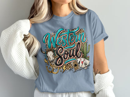 Western Soul text with skull, horseshoe, cacti, and playing cards on a blue t-shirt.