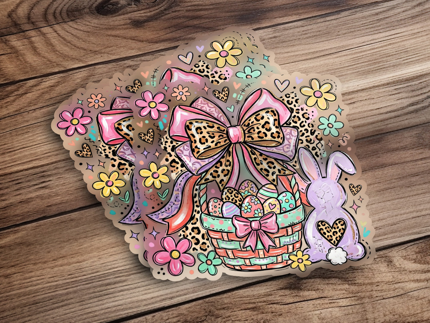 Easter basket with eggs, bow, flowers, and bunny on wood background.