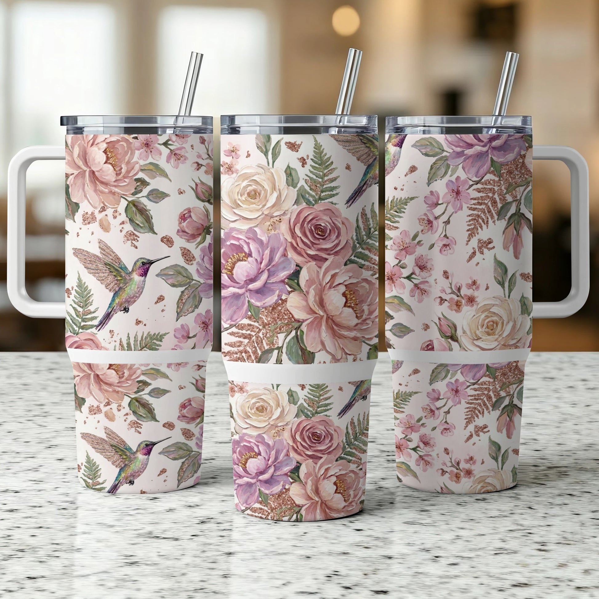 Three tumblers with a floral and hummingbird pattern and reusable straws.