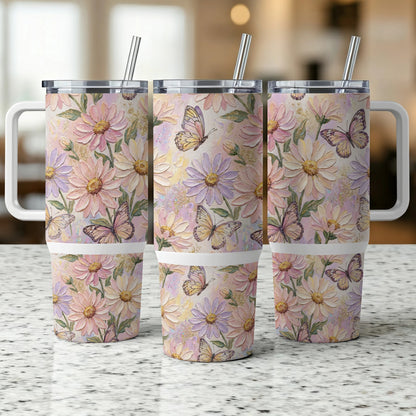 Three tumblers with floral and butterfly patterns and metal straws.