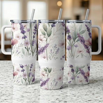 Three floral patterned tumblers with straws, on a speckled surface.