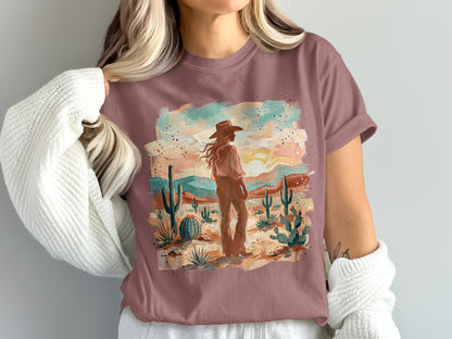Woman in a cowboy hat stands in a desert landscape on a t-shirt.