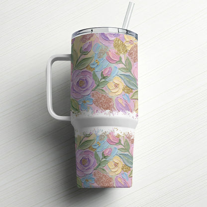 Floral textured tumbler with handle and straw on a white wooden surface.