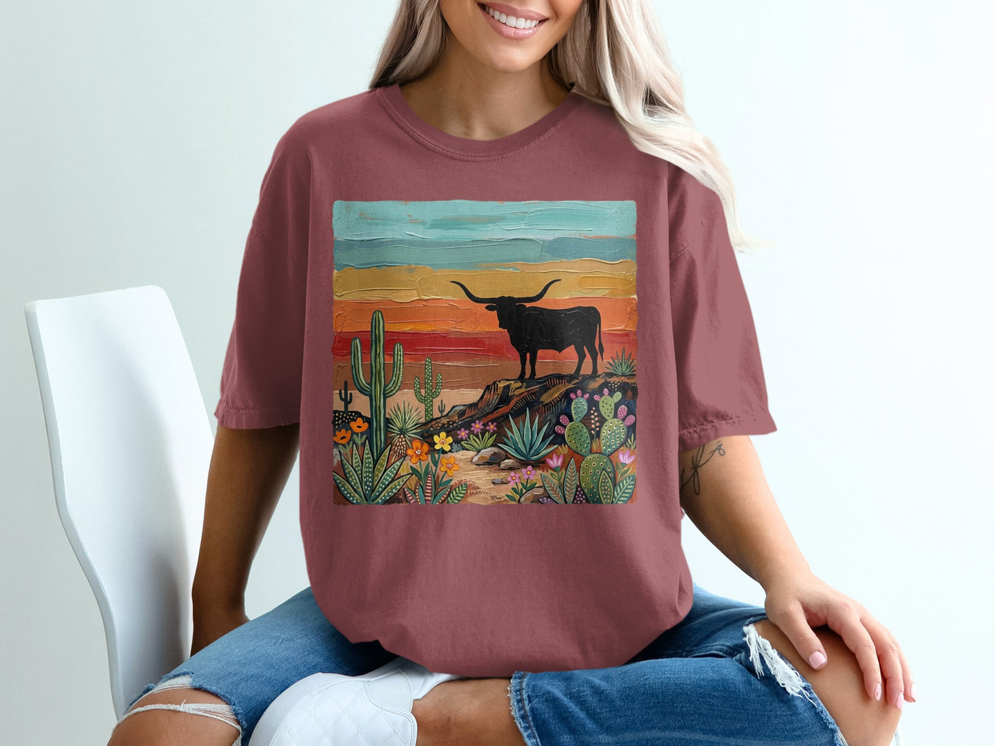 T-shirt with a desert landscape and longhorn cattle graphic.