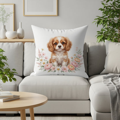 Cavalier King Charles Spaniel puppy on cushion surrounded by flowers.
