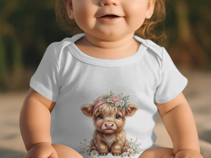 Baby wearing a white bodysuit with a cute highland cow and flowers graphic.