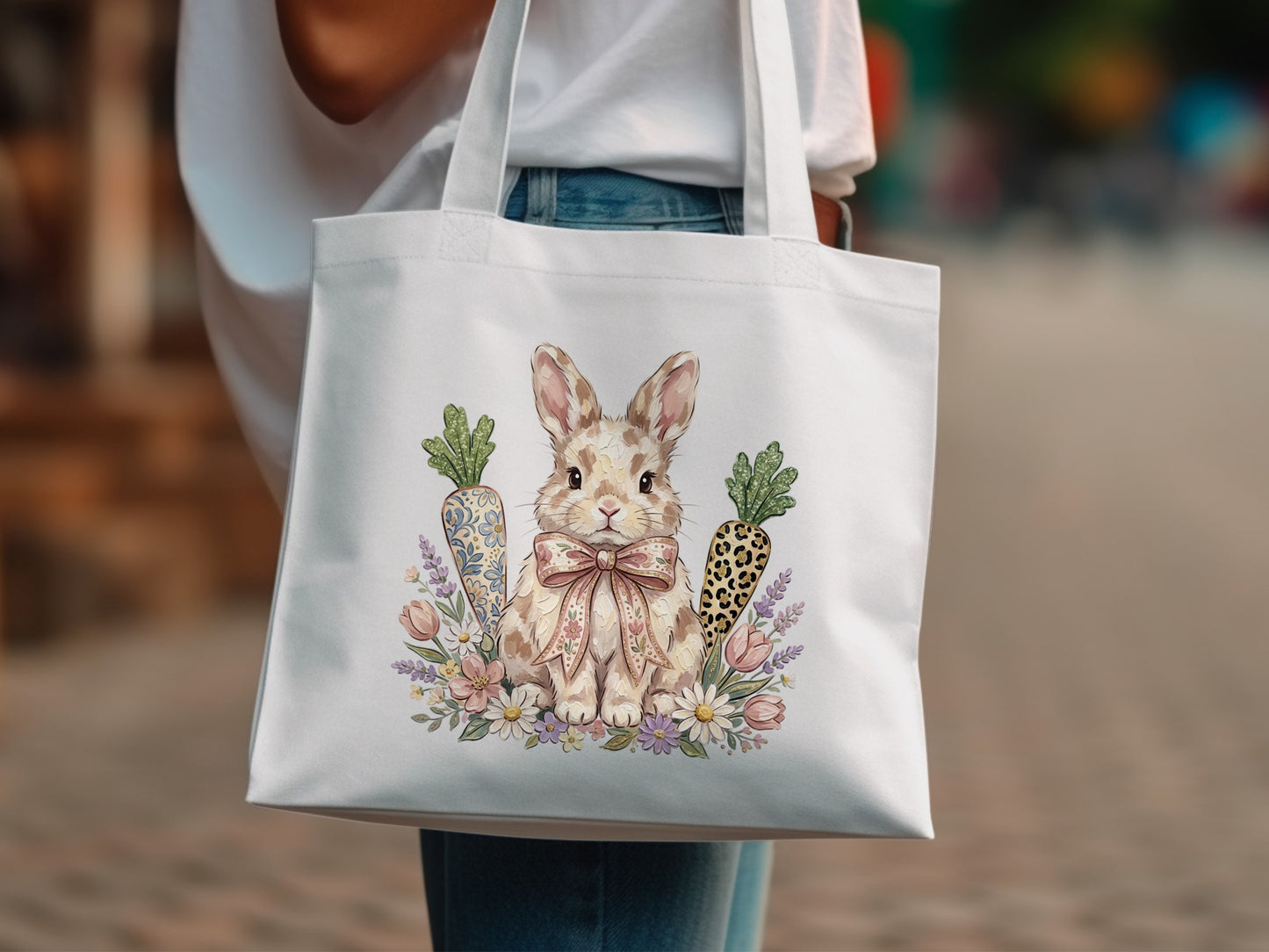 White tote bag with a watercolor rabbit, carrots, and flowers.