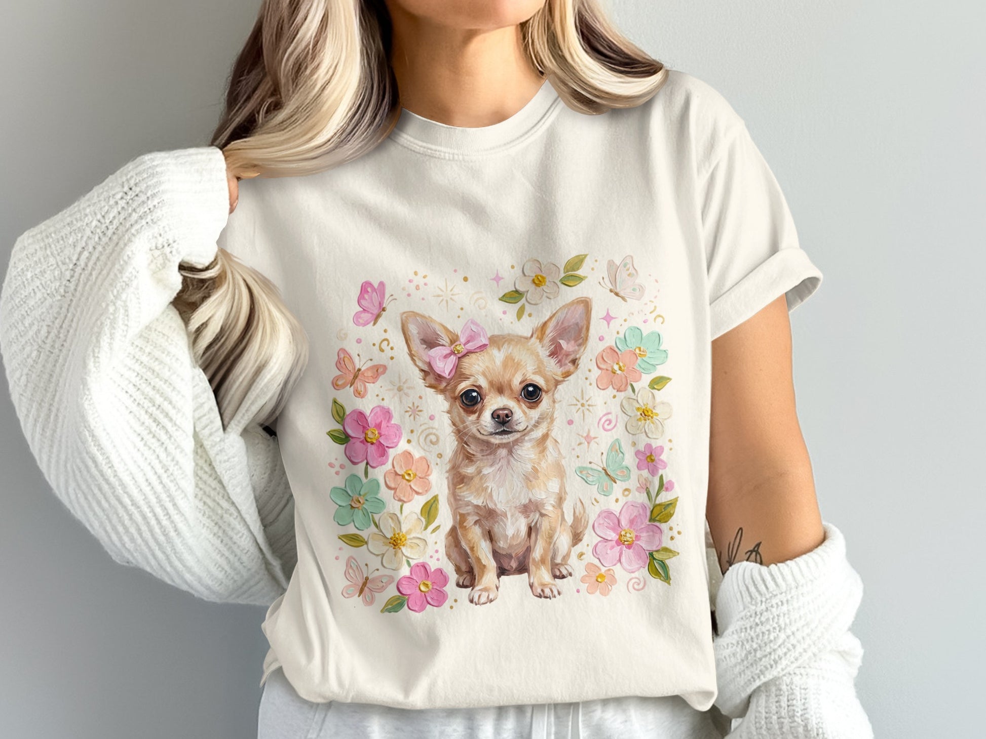 Cream t-shirt with chihuahua wearing pink bow surrounded by flowers and butterflies.