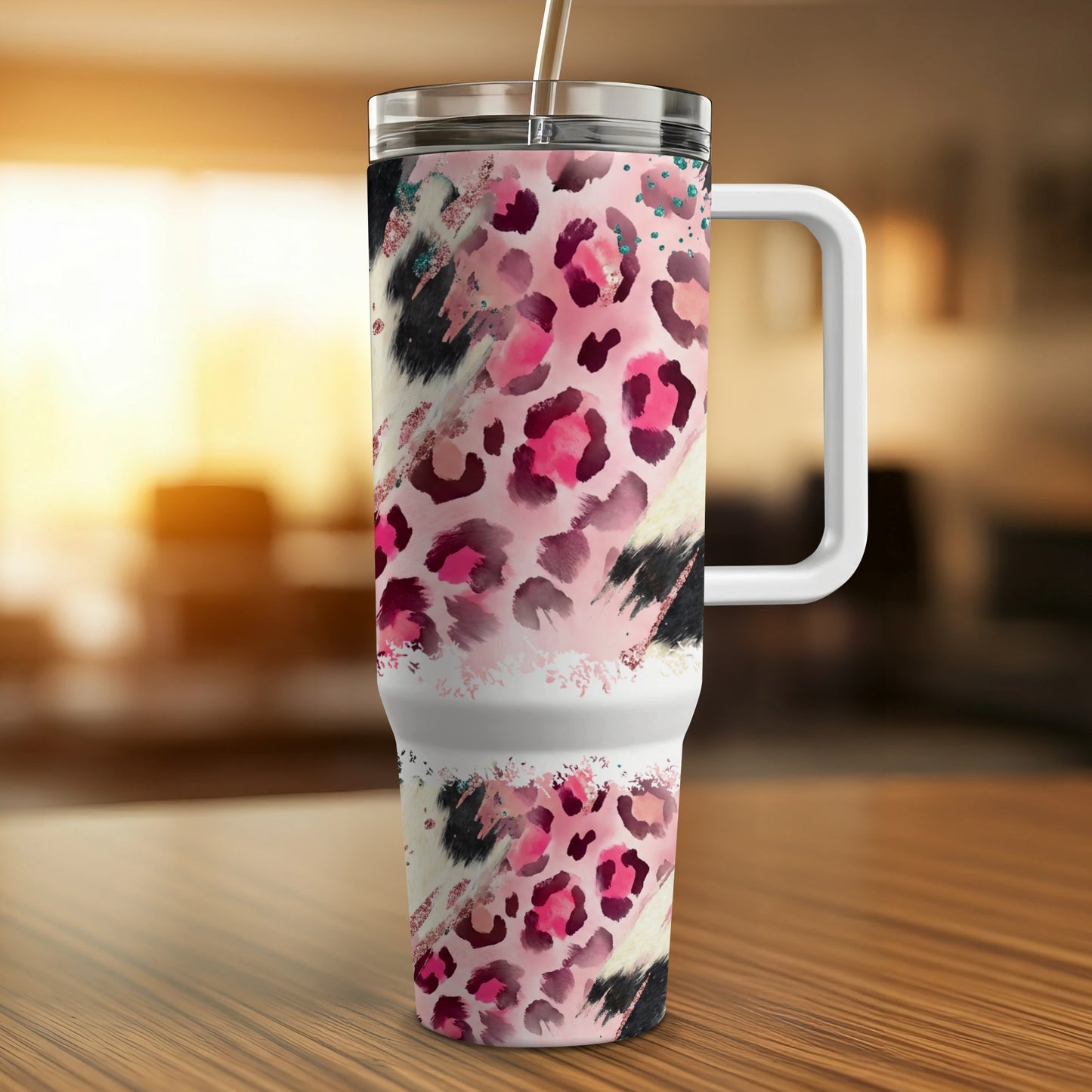 Pink and black leopard print tumbler with white handle and straw.