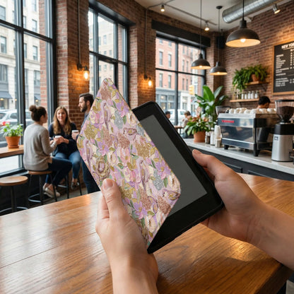 Person holding a tablet with a floral and bird patterned case.