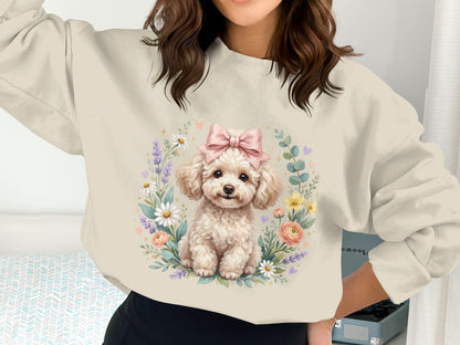 Cream sweatshirt with a fluffy white poodle wearing a pink bow surrounded by flowers.