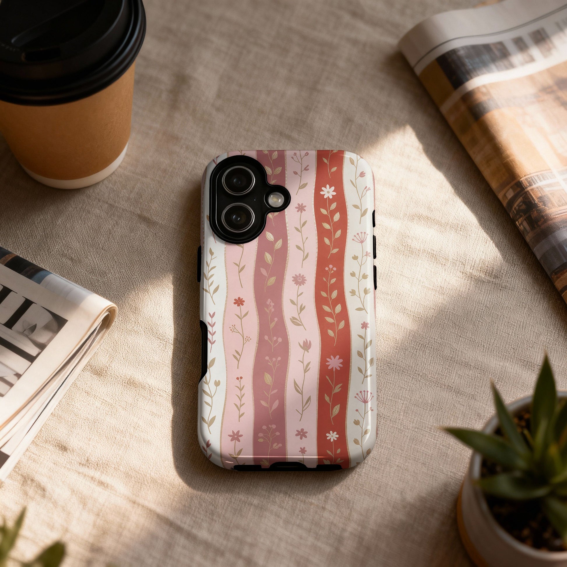 Pink and white floral wavy stripe pattern iPhone case on textured surface.