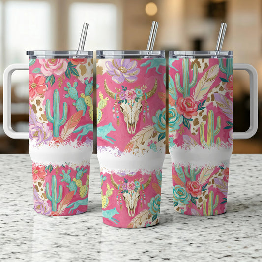 Pink tumbler with cactus, floral, and bull skull designs.