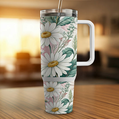 White daisies and green leaves pattern on a tall tumbler with a handle.