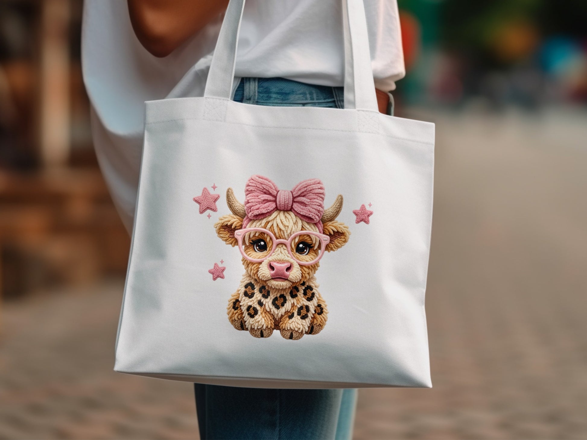 White tote bag with a cartoon highland cow wearing glasses and a bow.