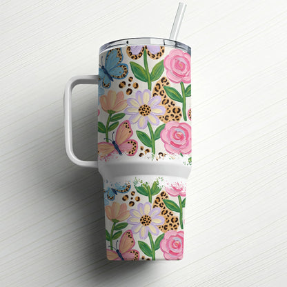 Floral and butterfly pattern tumbler with handle and straw.