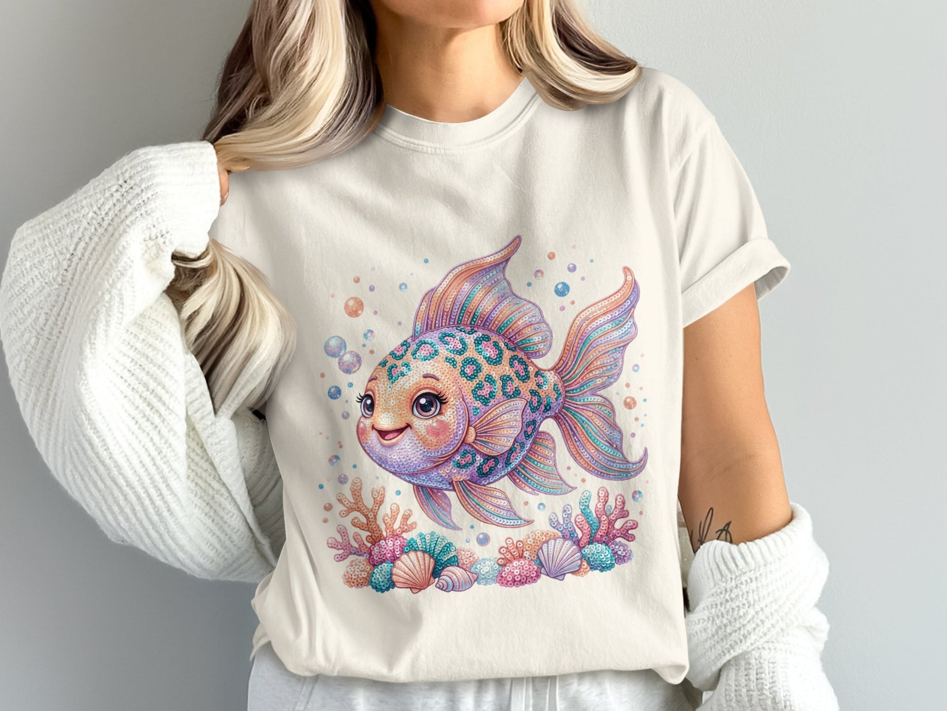 Whimsical patterned goldfish with coral and bubbles on a cream t-shirt.