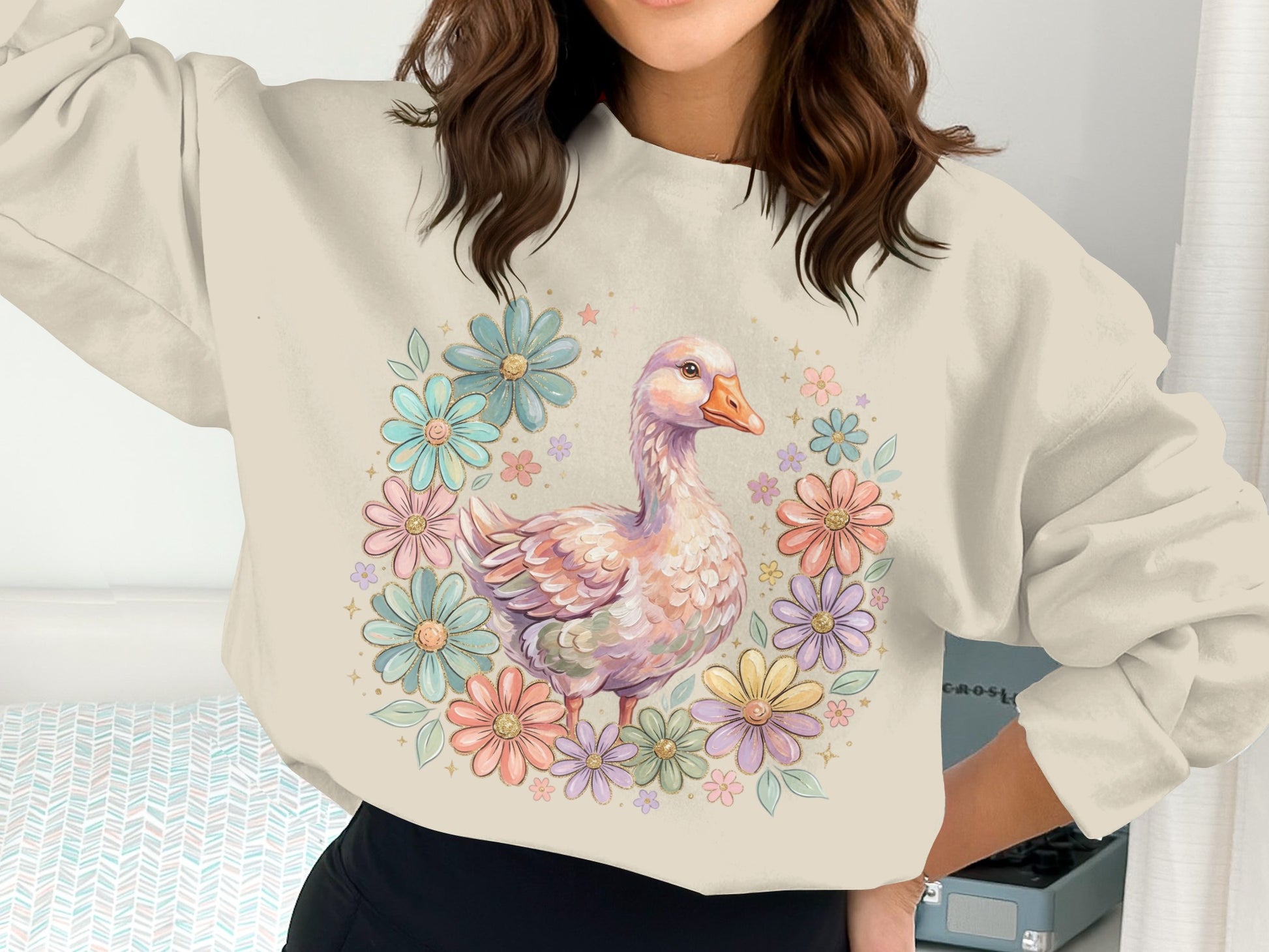 Cream sweatshirt with a pastel floral wreath and goose graphic.