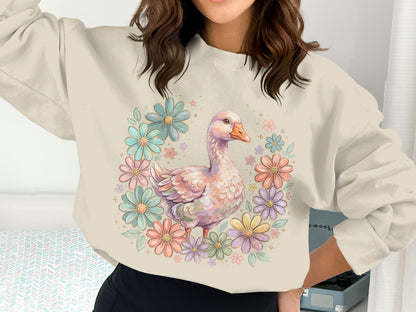 Cream sweatshirt with a pastel floral wreath and goose graphic.