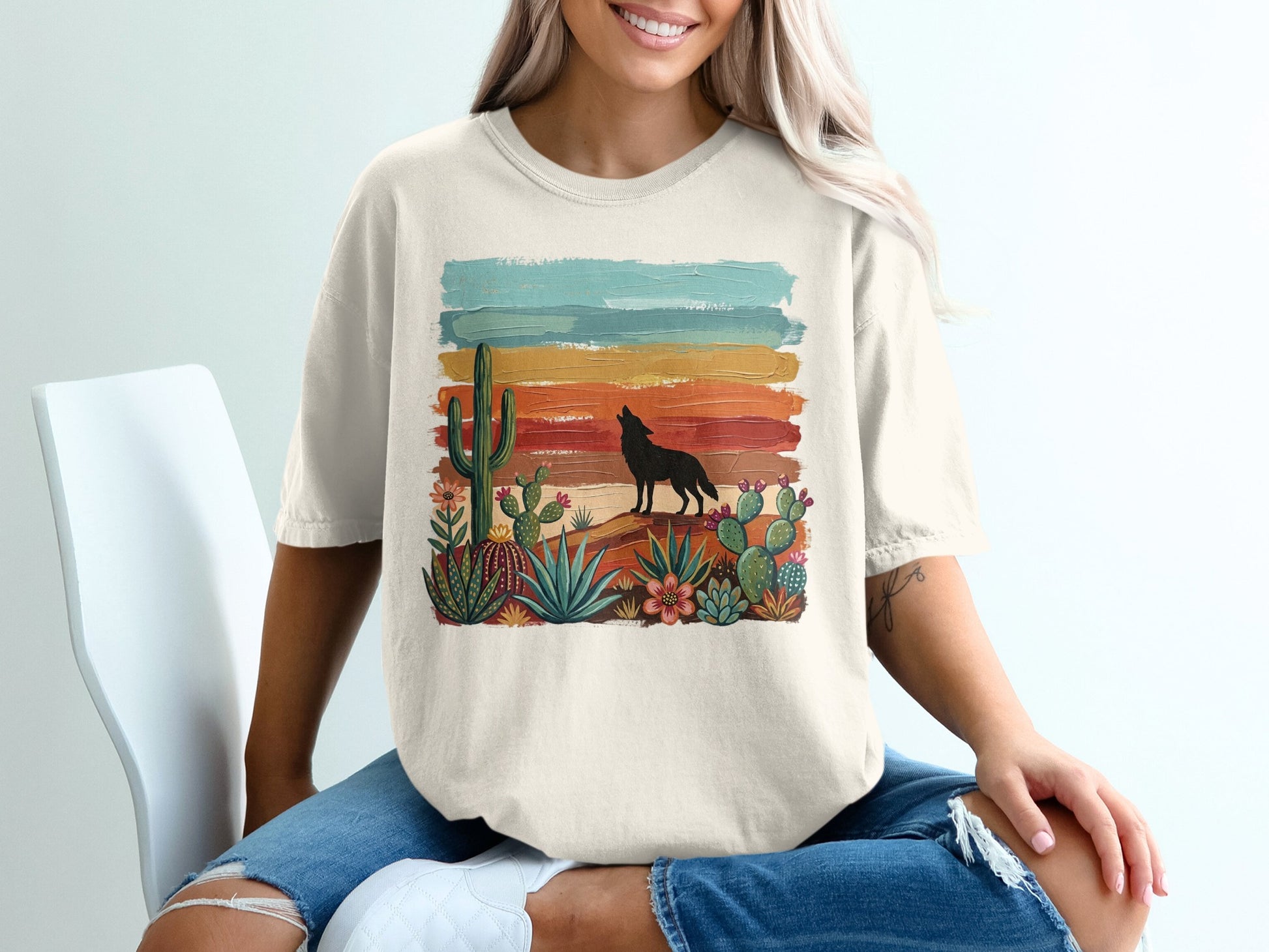 Cream t-shirt with a desert landscape featuring a howling wolf and cacti.
