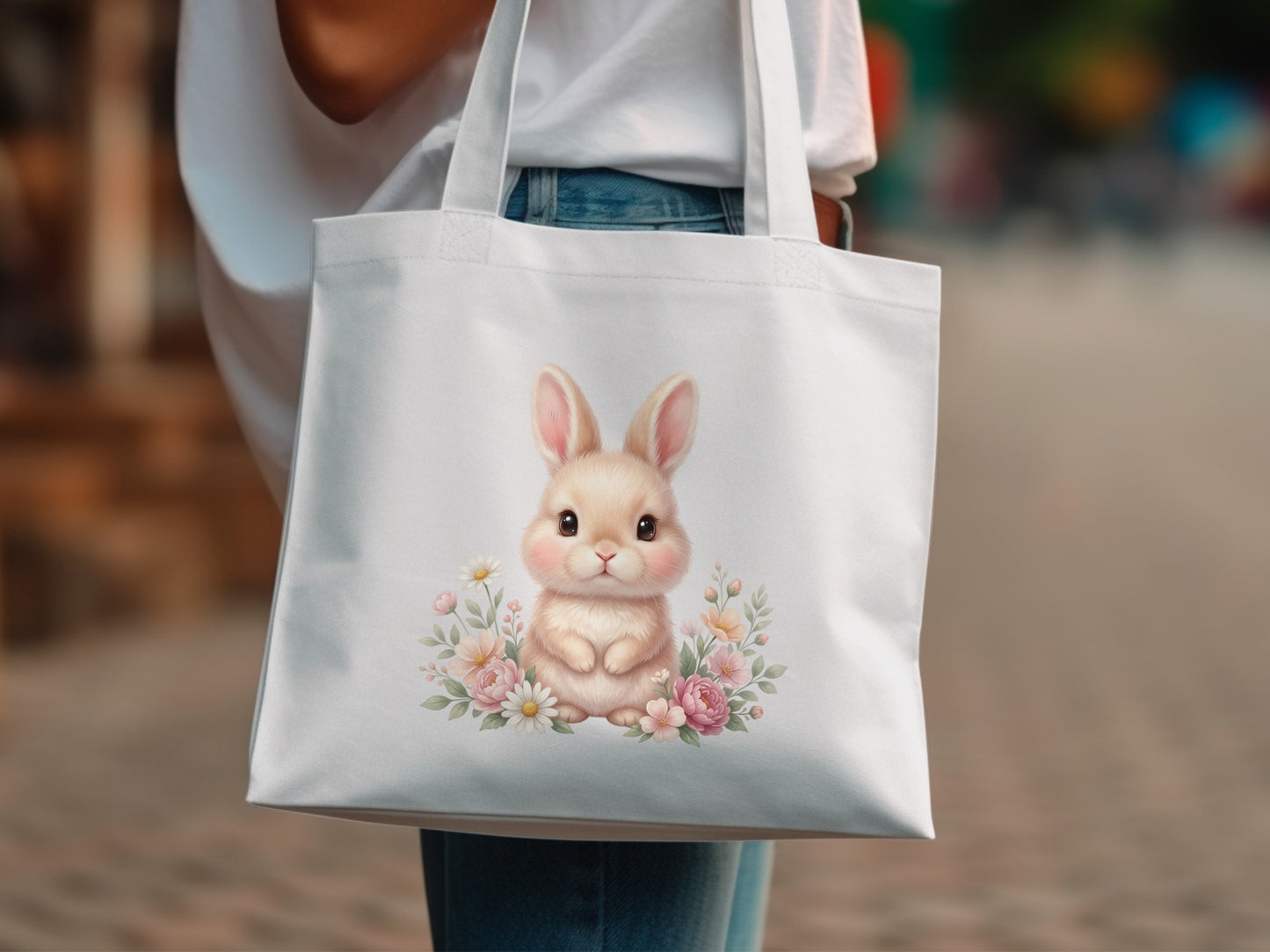 White tote bag with a cute bunny illustration surrounded by flowers.