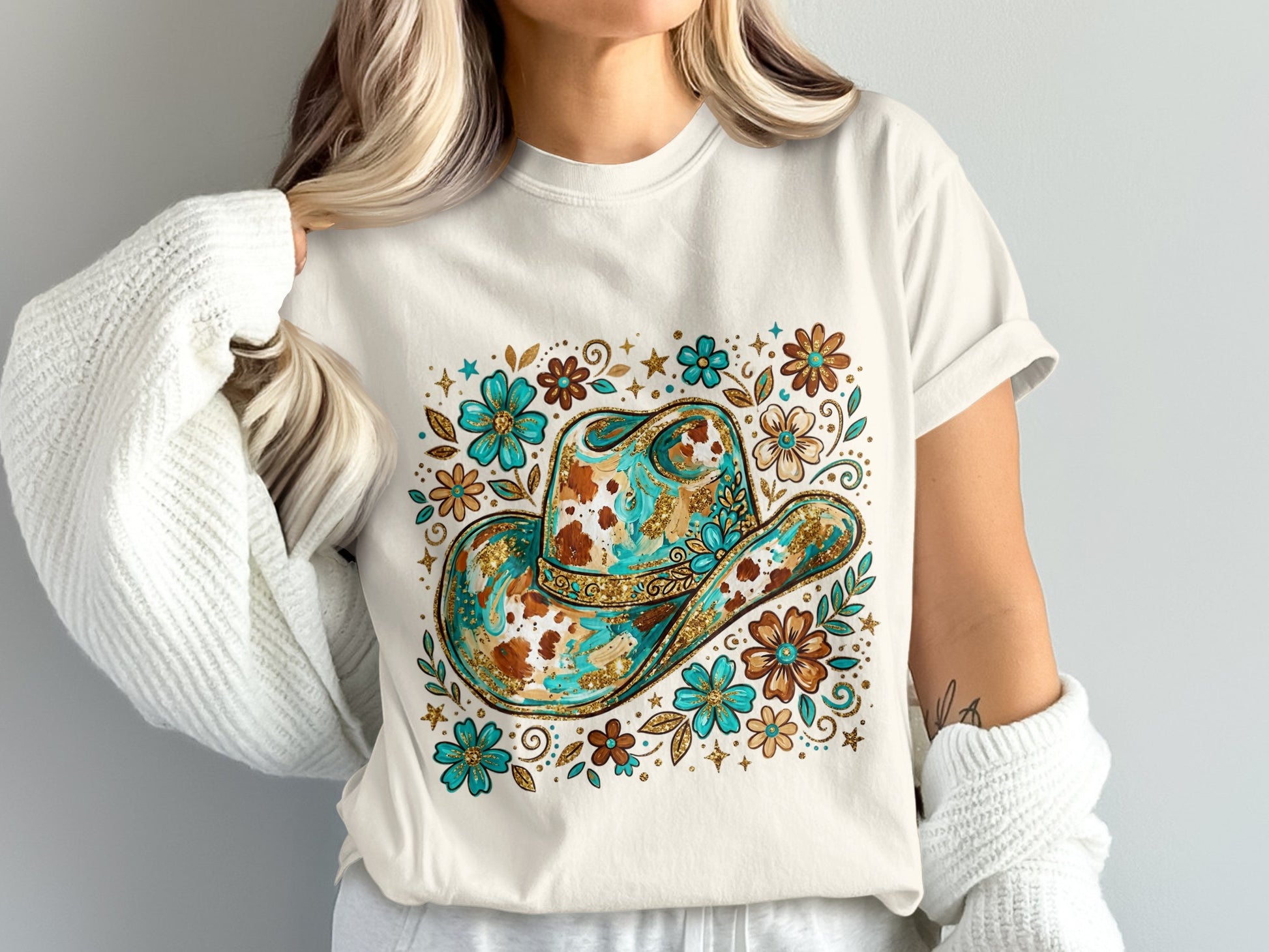 White t-shirt with a decorated cowboy hat and floral design.
