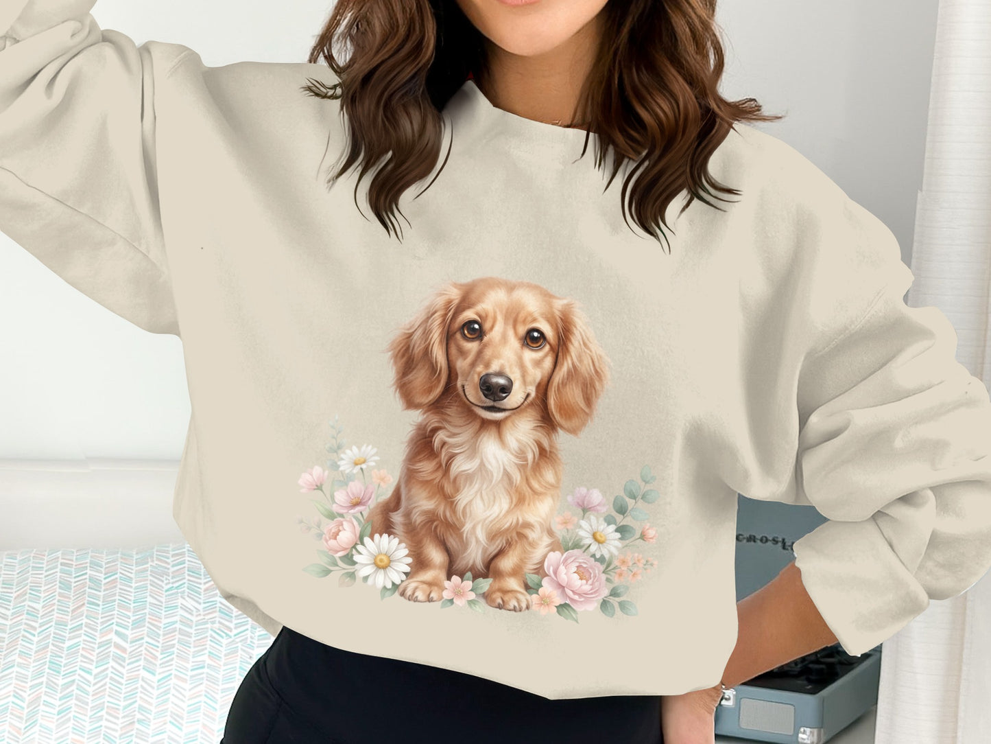 Dachshund illustration with floral accents on a cream sweatshirt.