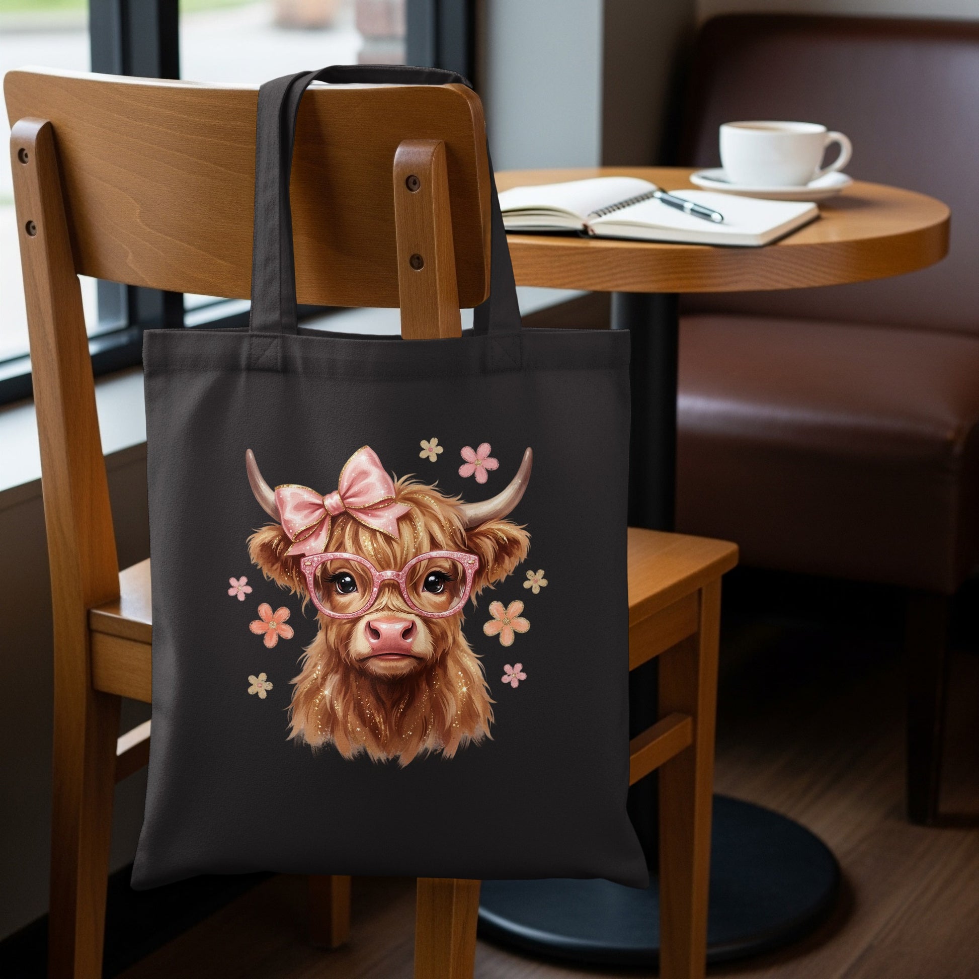Black tote bag with cute illustrated Highland cow wearing pink glasses and bow.