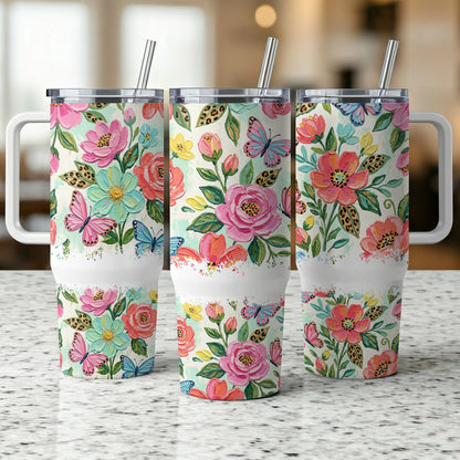 Three tumblers with floral and butterfly designs, each with a white band.