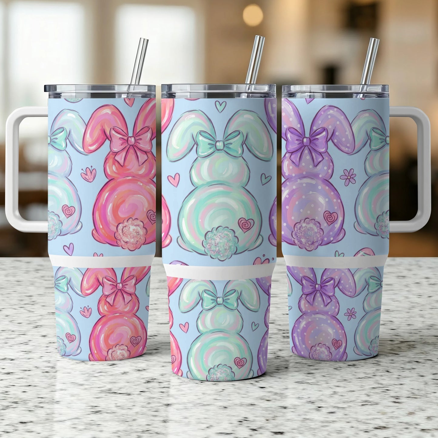 Three pastel bunny tumblers with bows and polka dots on a counter.