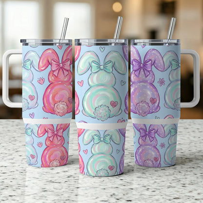 Three pastel bunny tumblers with bows and polka dots on a counter.