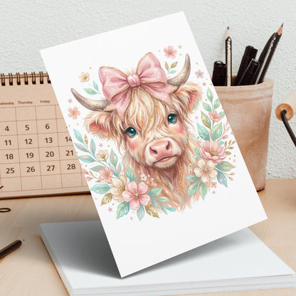 Whimsical Highland cow illustration with pink bow and pastel flowers.