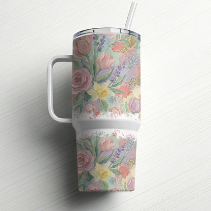 Floral patterned tumbler with straw on white wooden surface.
