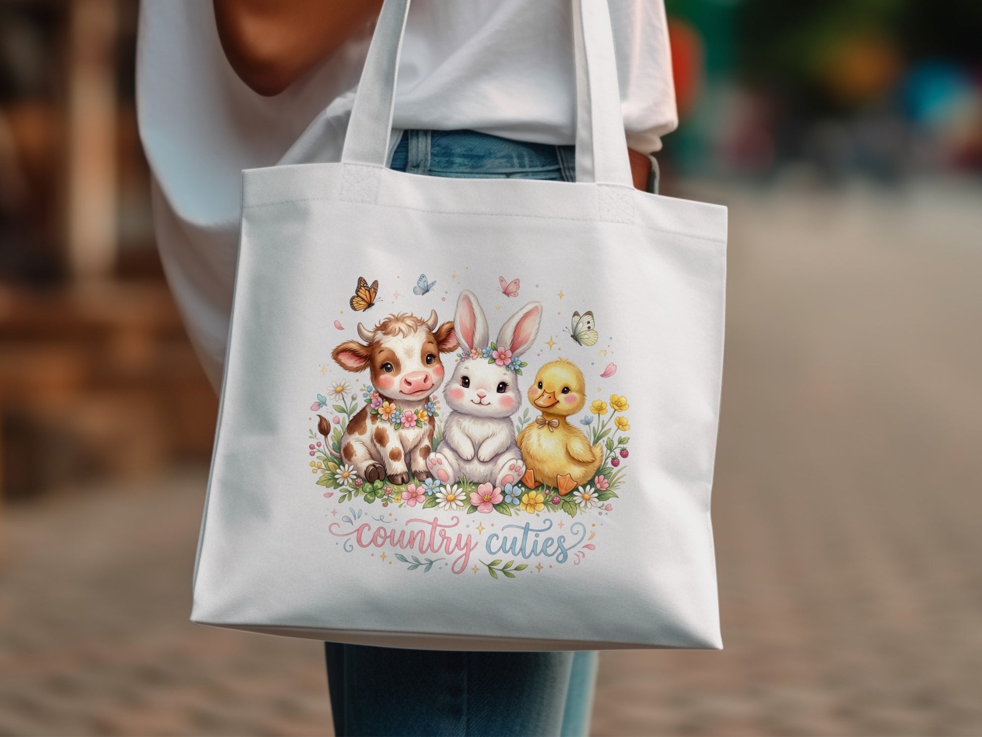 White tote bag with cartoon cow, bunny, and duckling surrounded by flowers.