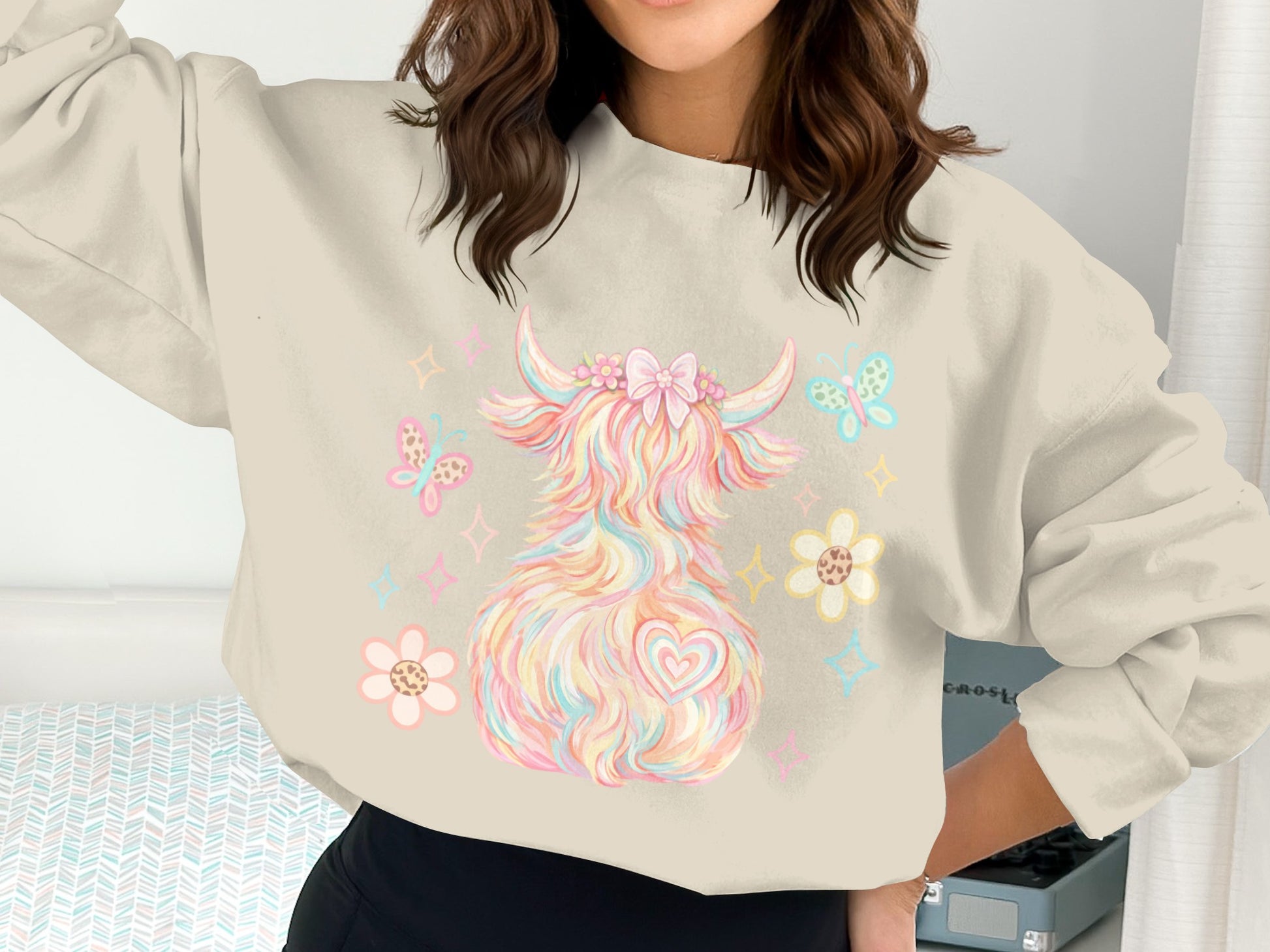 Sweatshirt featuring a pastel, fluffy cow with flowers and butterflies.