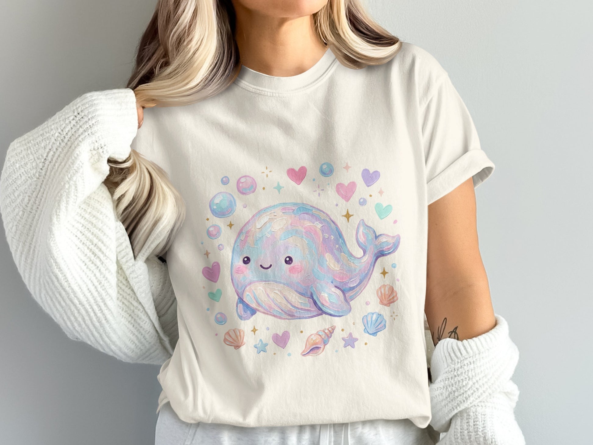 Cream t-shirt with a pastel watercolor whale, hearts, and seashells.