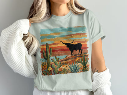 Light blue t-shirt with desert landscape featuring a longhorn bull and cacti.