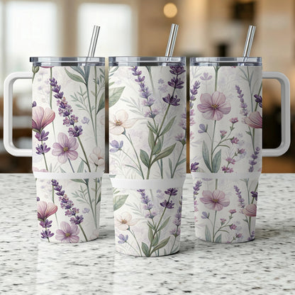 Three floral patterned tumblers with handles and straws.