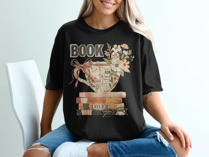 Black t-shirt with "BOOK" text and floral teacup design on stacked books.