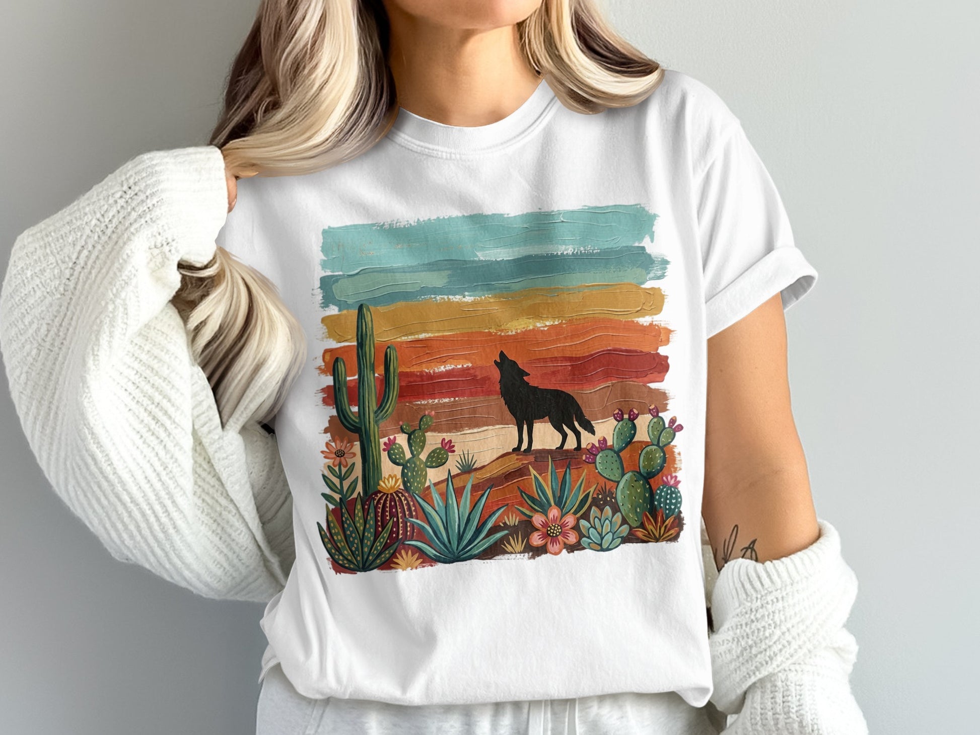 Black wolf silhouette howling at colorful desert sunset on a graphic t-shirt.