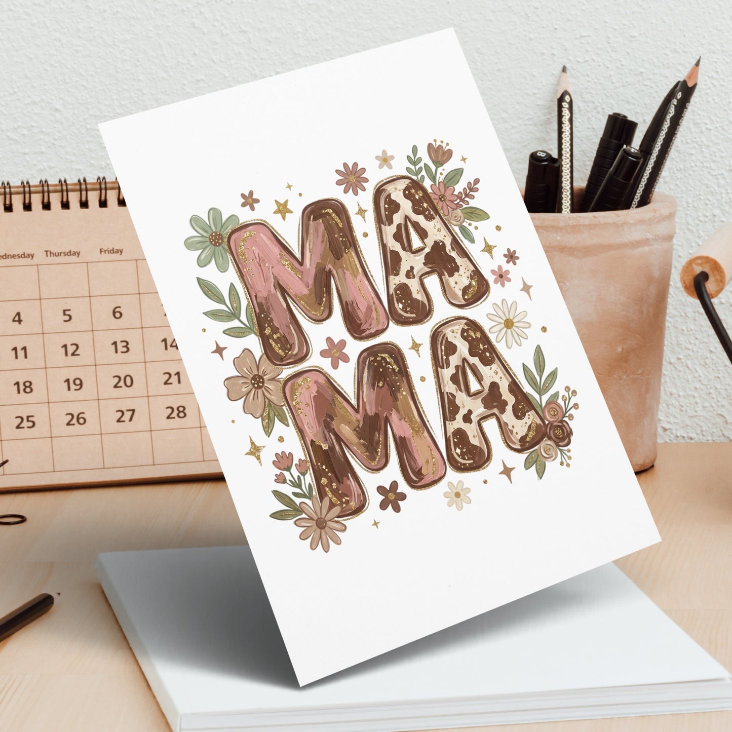 "MAMA" text with floral and cow print accents on a card.