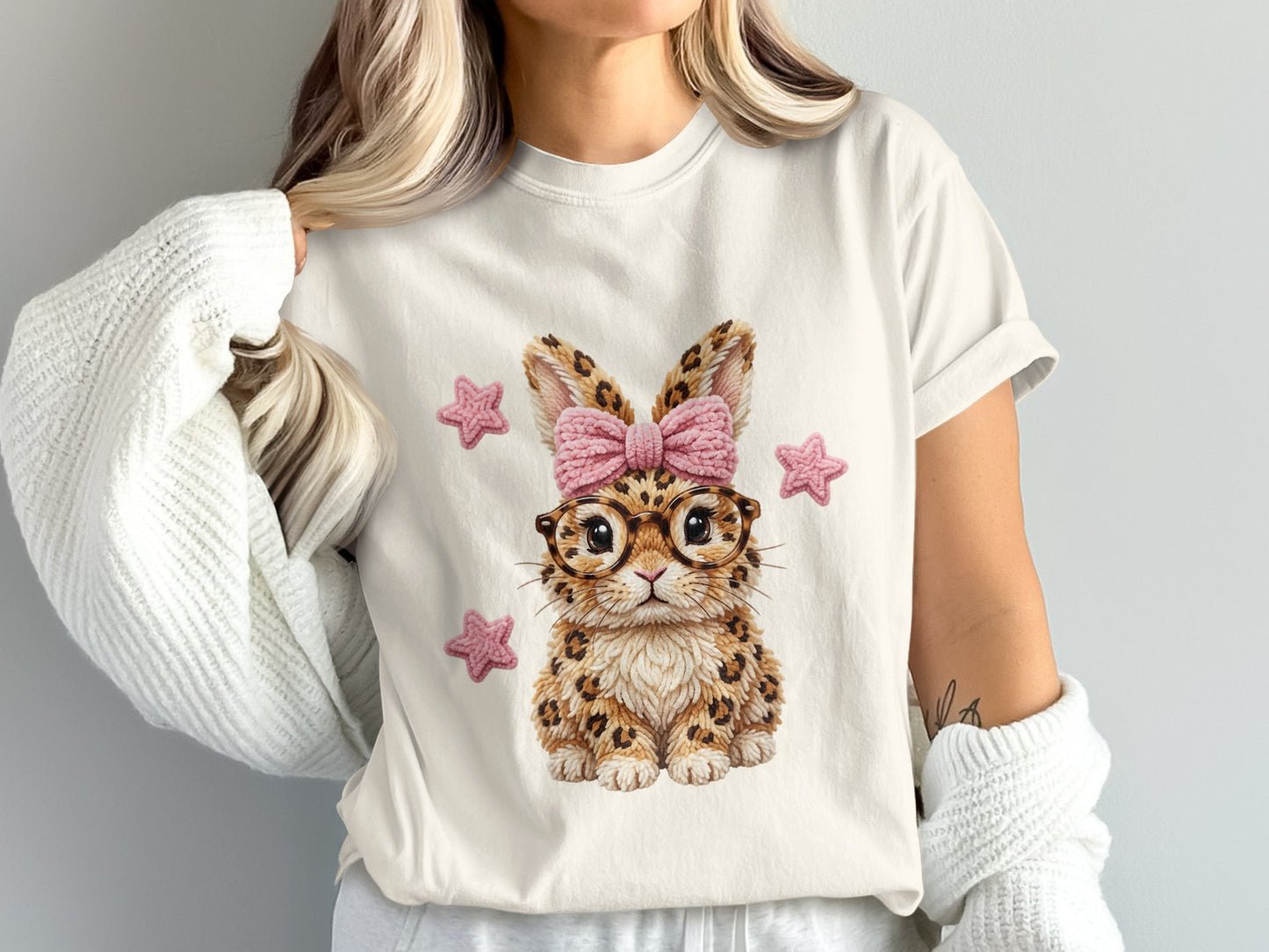 T-shirt with a cartoon cheetah bunny wearing glasses and a pink bow.