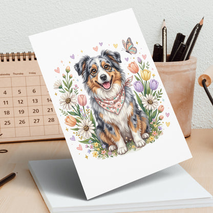 Australian Shepherd dog with bandana in a field of flowers.