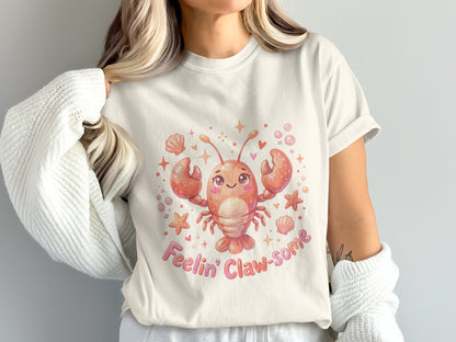 Cream t-shirt with smiling lobster graphic and "Feelin' Claw-some" text.