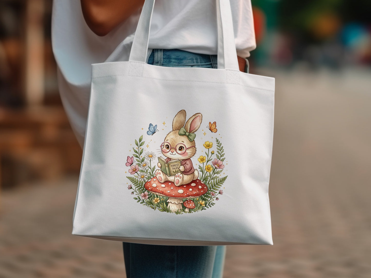 Tote bag with illustration of a bunny reading a book on a mushroom.