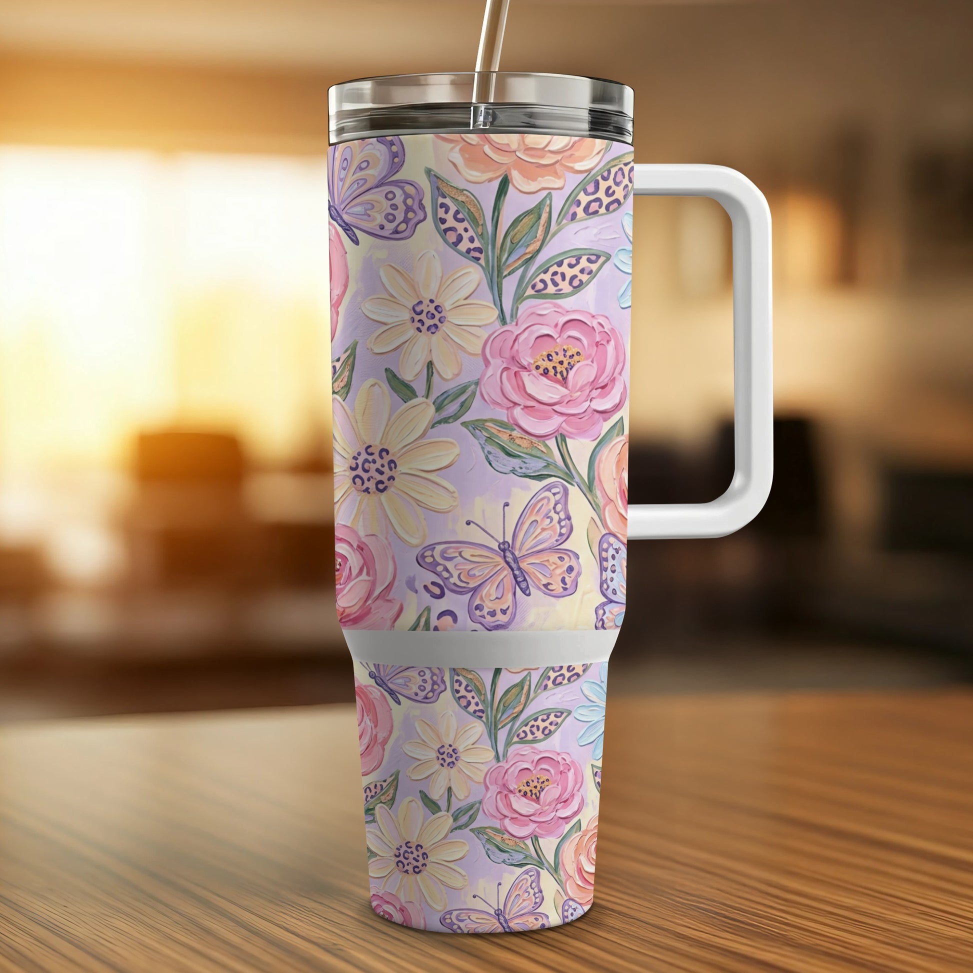 Floral and butterfly patterned tumbler with handle and straw.