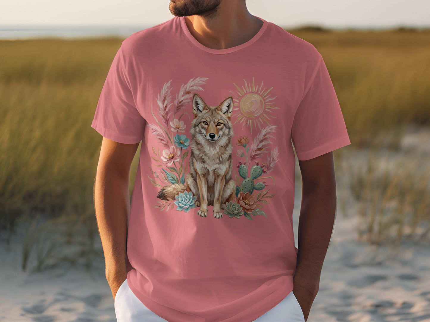 T-shirt with a desert coyote, cactus, and sun design on pink fabric.