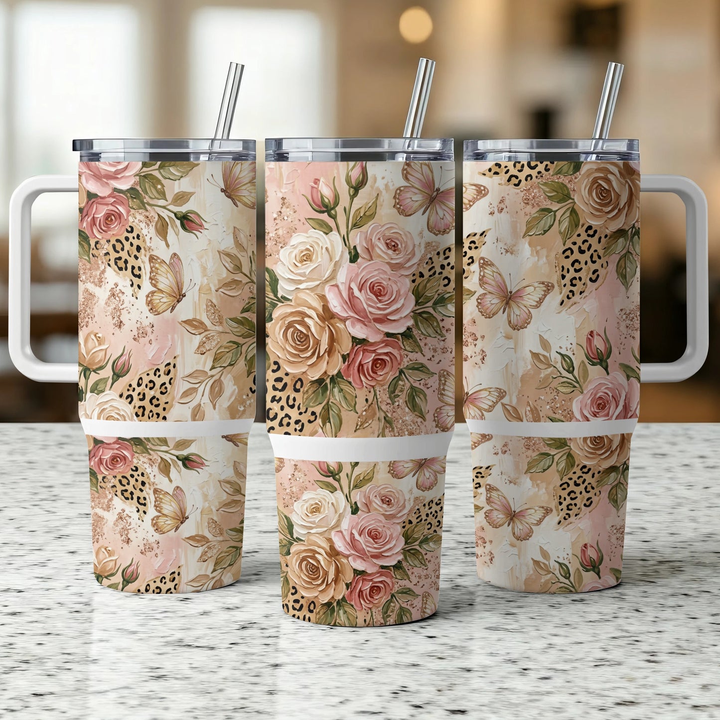 Three floral and butterfly patterned tumblers with handles and straws.